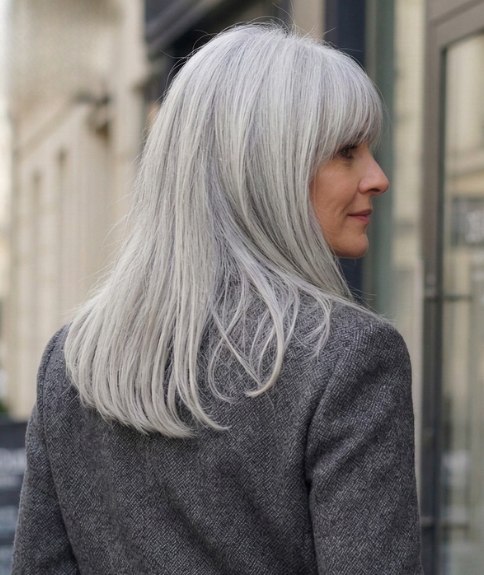 Femme aux longs cheveux gris au look rajeunissant