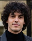 Un homme aux cheveux bouclés jusqu’au col